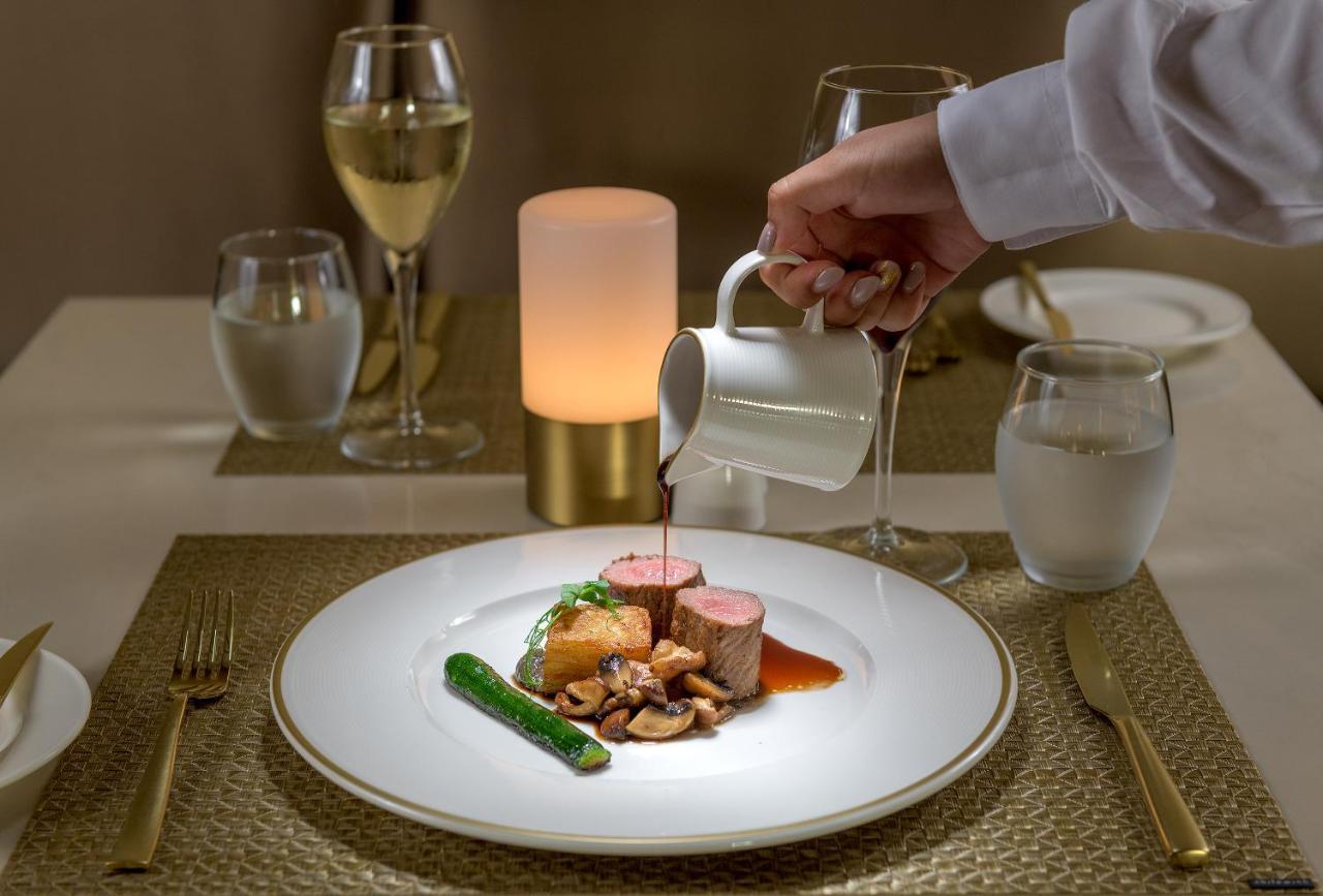 Amarande (Adults Only) Hotel Айя Напа Екстериор снимка A server pouring sauce onto a plate of food